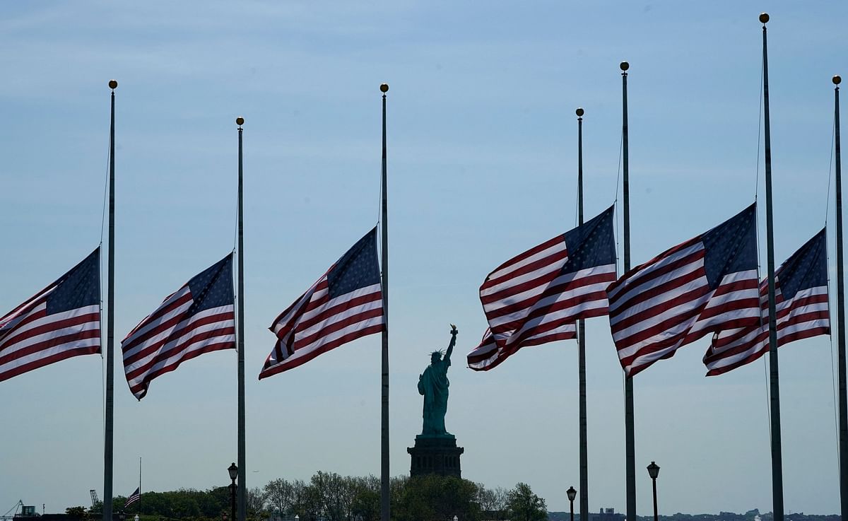 US flags, across New York Bay from the Statue of Liberty, fly at half-mastat Liberty State Park in Jersey City, New Jersey, on May 25, 2022, as a mark of respect for the victims of the May 24 shooting at Robb Elementary School in Uvalde. Credit: AFP Photo