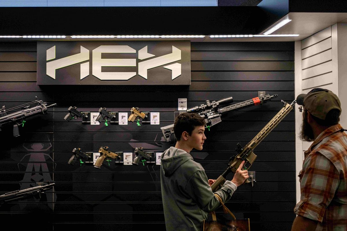 young boy examines a rifle at the George R. Brown Convention Center during the National Rifle Association (NRA) annual convention.  Credit: AFP
