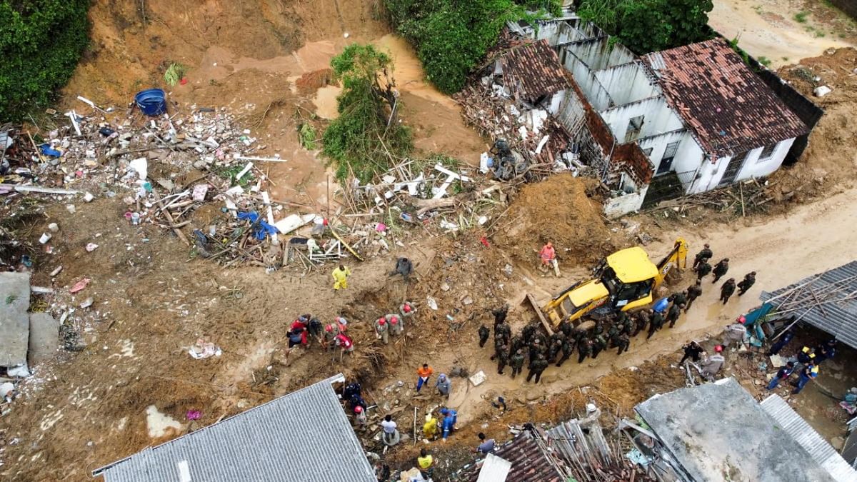 Firefighters, volunteers and army officers work on the site where a house collapsed due to a landslide caused by heavy rains at Jardim Monte Verde, in Ibura neighbourhood, in Recife, Brazil. Credit: Reuters photo