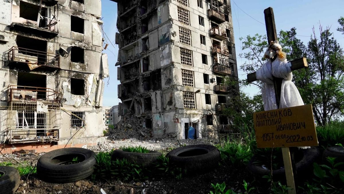 A grave is pictured in front of destroyed residential buildings in Mariupol on May 31, 2022, amid the ongoing military action in Ukraine. Credit: AFP Photo