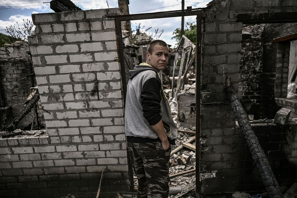 Ivan Sosnin, 19, stands in front of his destroyed house in the city of Lysychansk at the eastern Ukrainian region of Donbas. Credit: AFP Photo