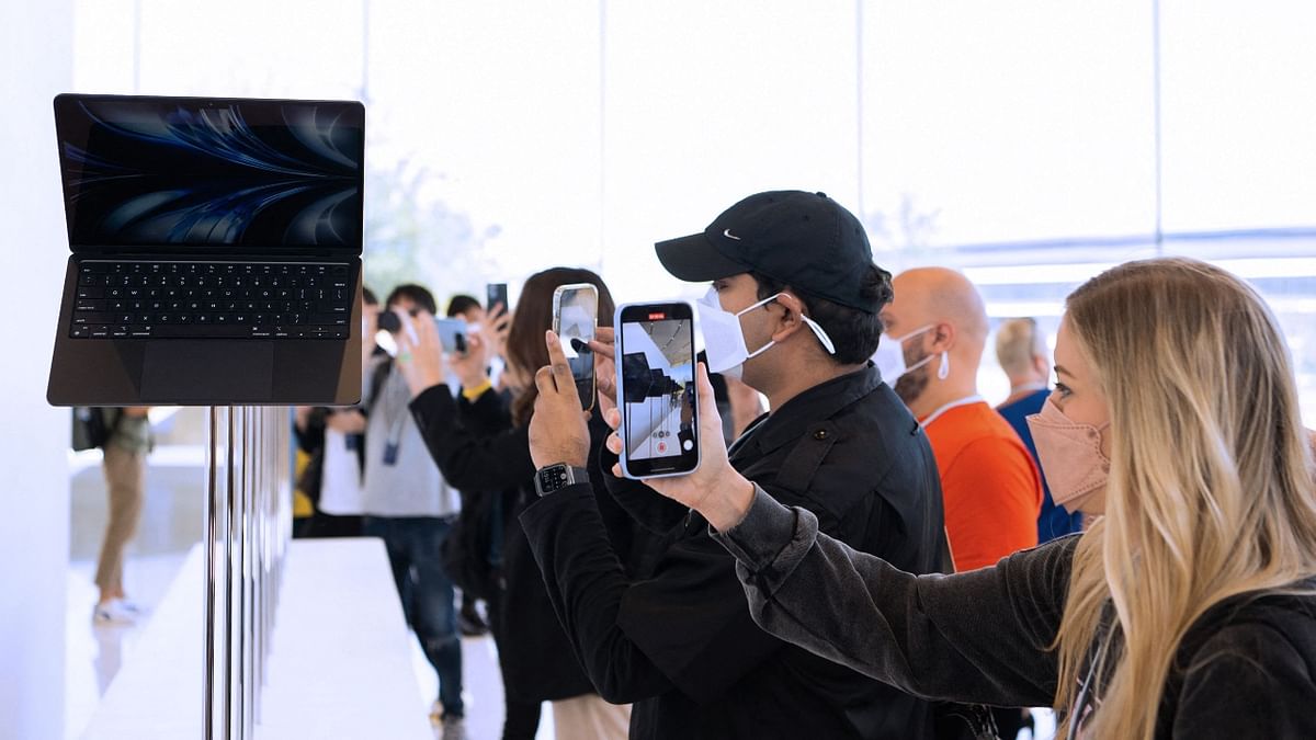 Attendees take photos of the new MacBook Airs which are displayed inside the Steve Jobs Theater during the Apple Worldwide Developers Conference (WWDC) at the Apple Park campus in Cupertino, California. Credit: AFP Photo