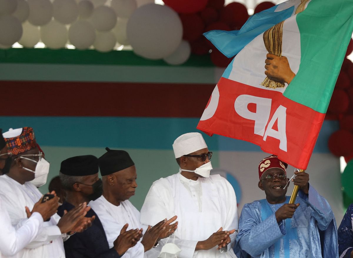 Nigeria’s ruling party (All Progressive Congress) presidential flagbearer, Bola Tinubu (middle) is flanked by Nigeria’s President Muhammadu Buhari (C) and APC Chairman Abdullahi Adamu (right) after the party announces Tinubu as the winner of its presidential primary. Credit: AFP Photo