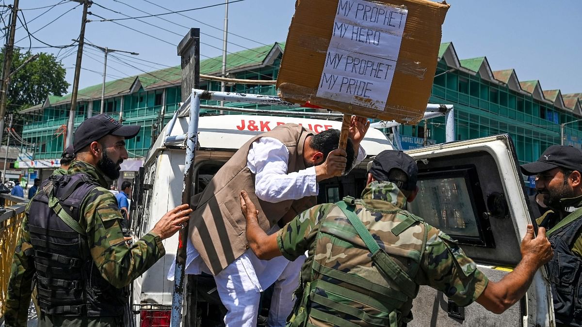 Police fired in air besides resorted to lathi-charge to control the mob which spilled out on the road after Friday prayers and pelted stones and shouted slogans at some places. In this photo, a policemen is seen detaining a protestor in Srinagar. Credit: AFP Photo