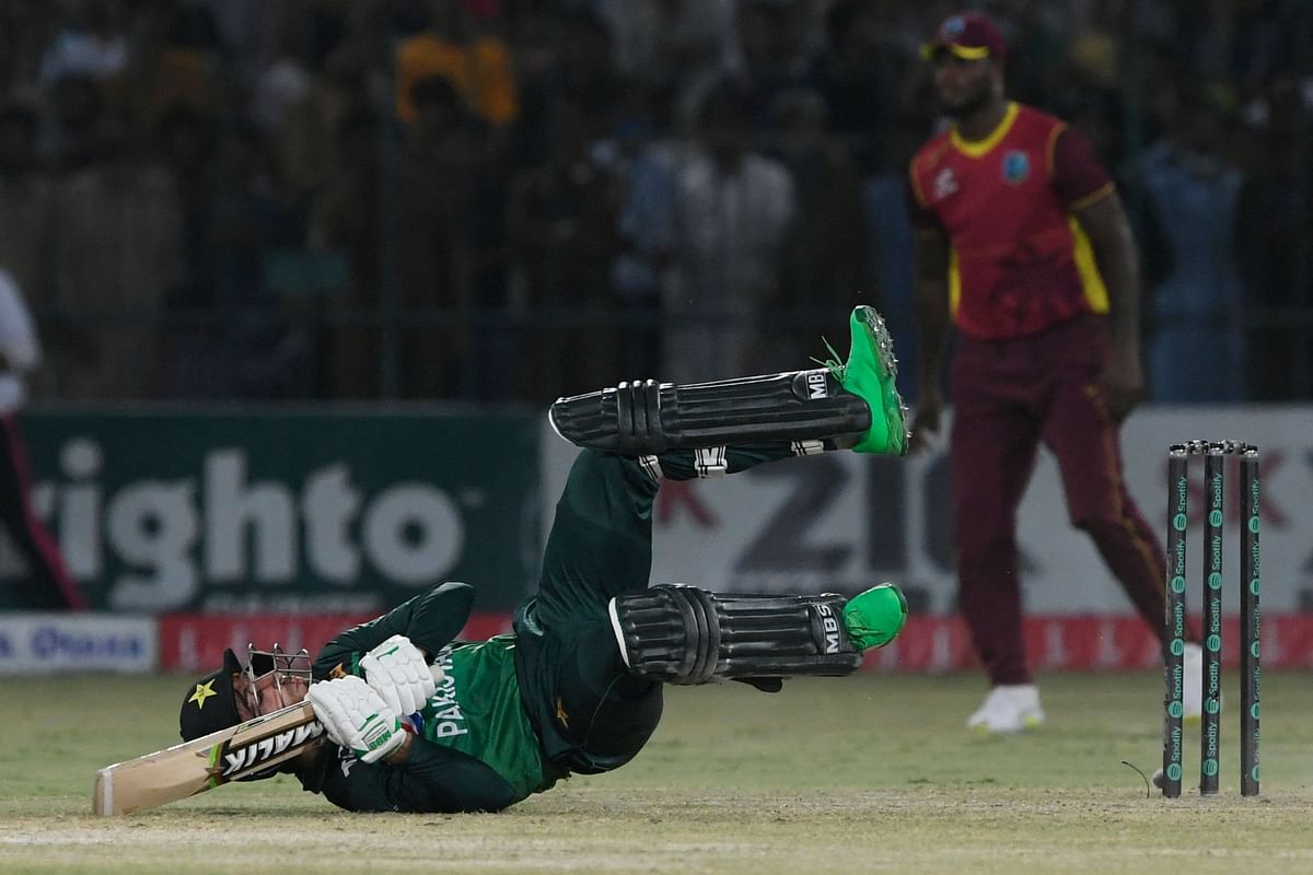 Pakistan's Mohammad Wasim (L) falls after playing a shot during the second one-day international (ODI) cricket match between Pakistan and West Indies at the Multan International Cricket Stadium in Multan. Credit: AFP Photo