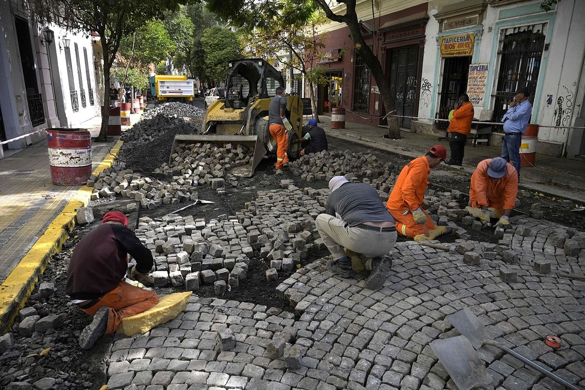 Workers restore cobblestone in a street in San Telmo neighborhood, Buenos Aires. Credit: AFP Photo