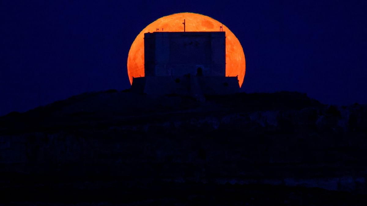 The 'Strawberry Moon' rises behind the 17th century Santa Marija Tower on Comino, the Maltese archipelago, Malta, Europe. Credit: Reuters Photo