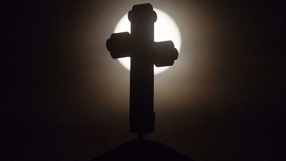The 'Strawberry supermoon', rises over a cross on the Church of St John, the Baptist in Skopje,  Macedonia. Credit: AFP Photo