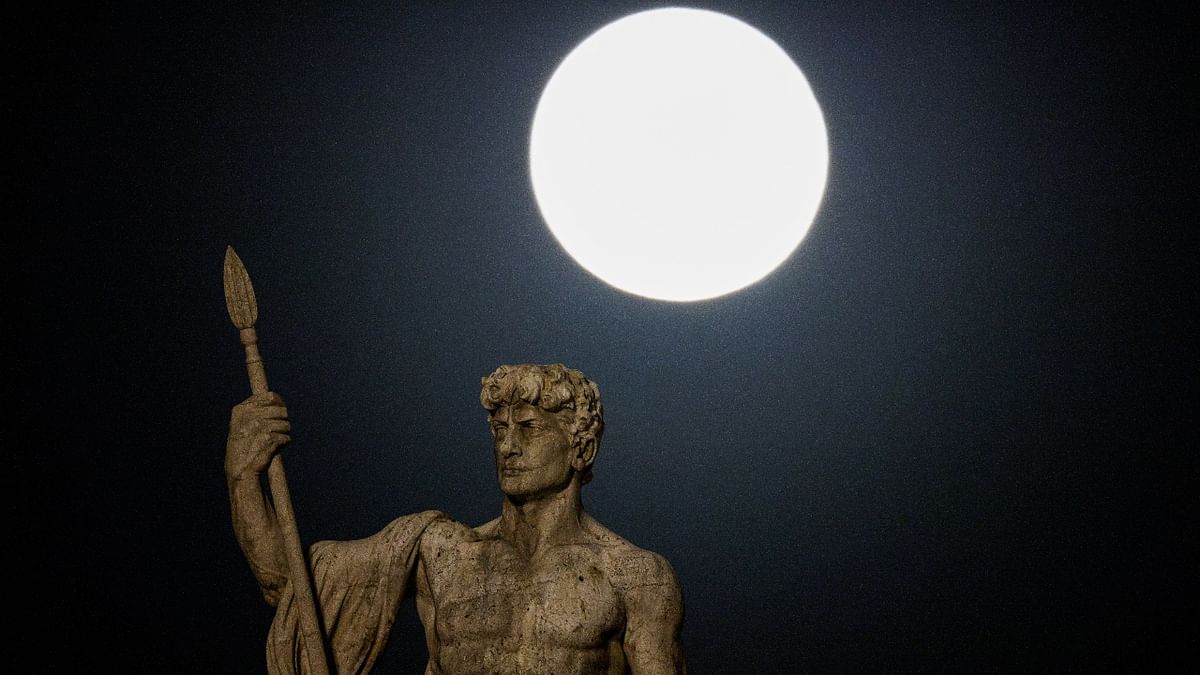 The full moon, also known as Strawberry Moon, rises behind a statue in Rome, Italy. Credit: AFP Photo