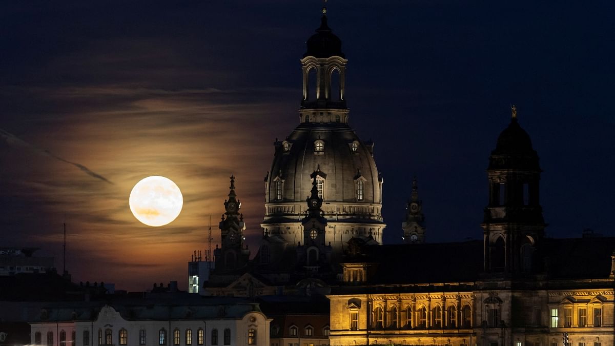 The 'Strawberry Moon' rises behind the old town district in Dresden, Germany. Credit: Reuters Photo