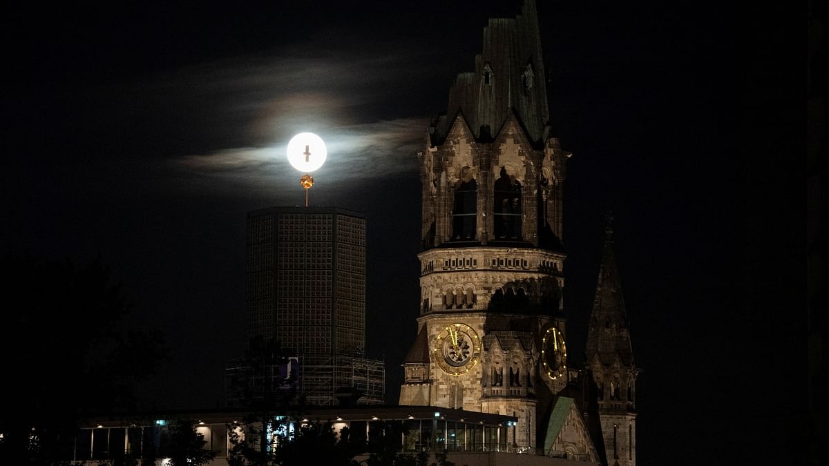 The 'Strawberry Moon' is seen behind the Kaiser Wilhelm Memorial Church in Berlin, Germany. Credit: Reuters Photo