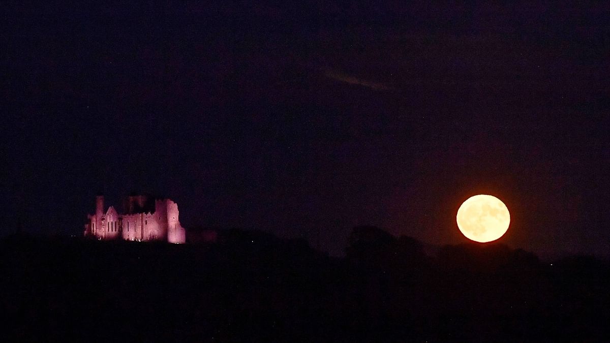 The 'Strawberry Moon' rises beside the Rock of Cashel, in Cashel, Ireland. Credit: Reuters Photo