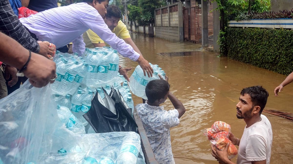 Guwahati Municipal Corporation (GMC) Mayor Mrigen Sarania distributes flood relief material to flood affected residents of Anil Nagar, in Guwahati. Credit: PTI Photo
