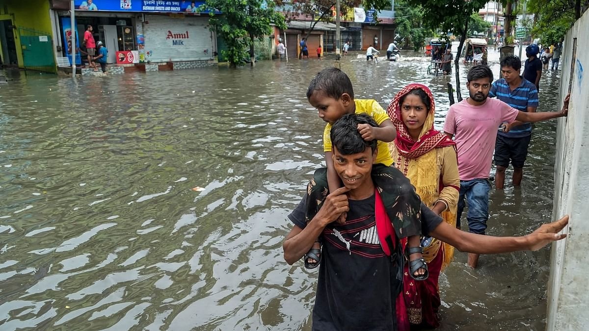 People wade through a waterlogged street after rain in Guwahati. Credit: PTI Photo