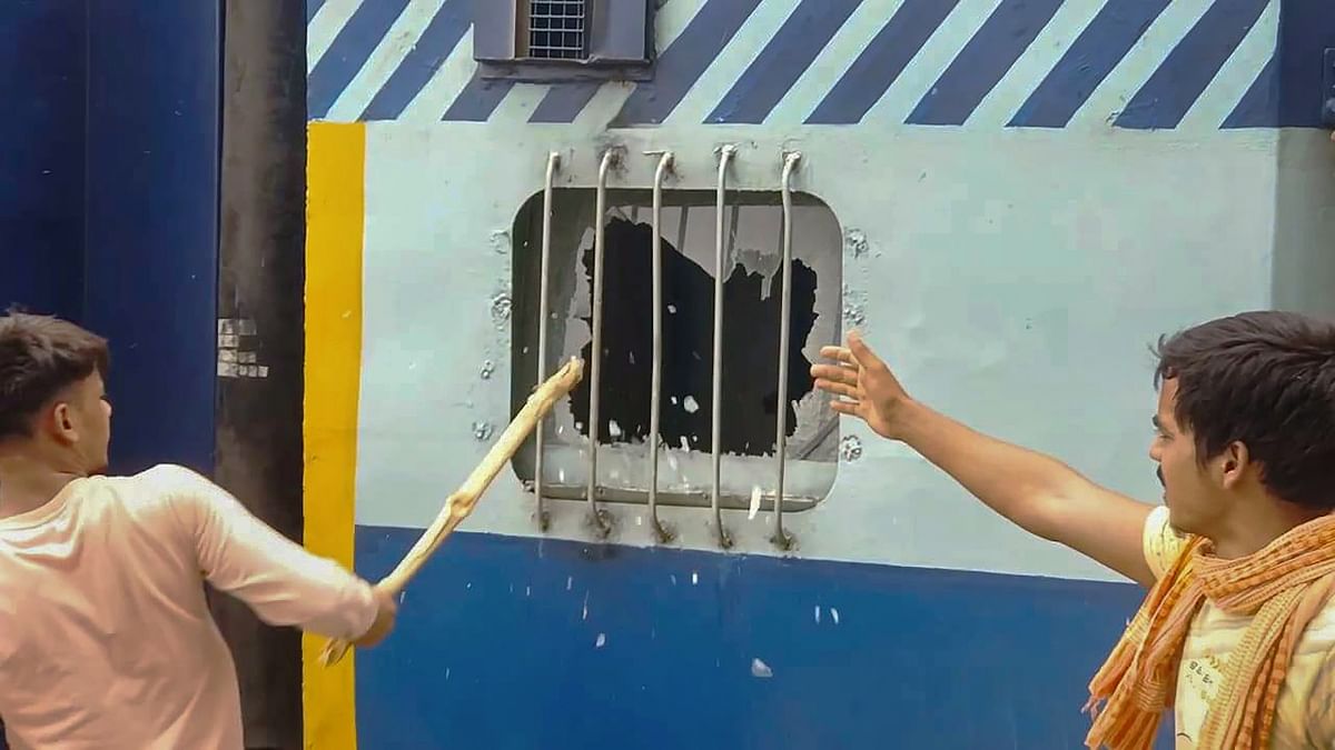 Youngsters vandalise a train in protest against the 'Agnipath' scheme, at Bhabua Station in Kaimur district of Bihar. Credit: PTI Photo