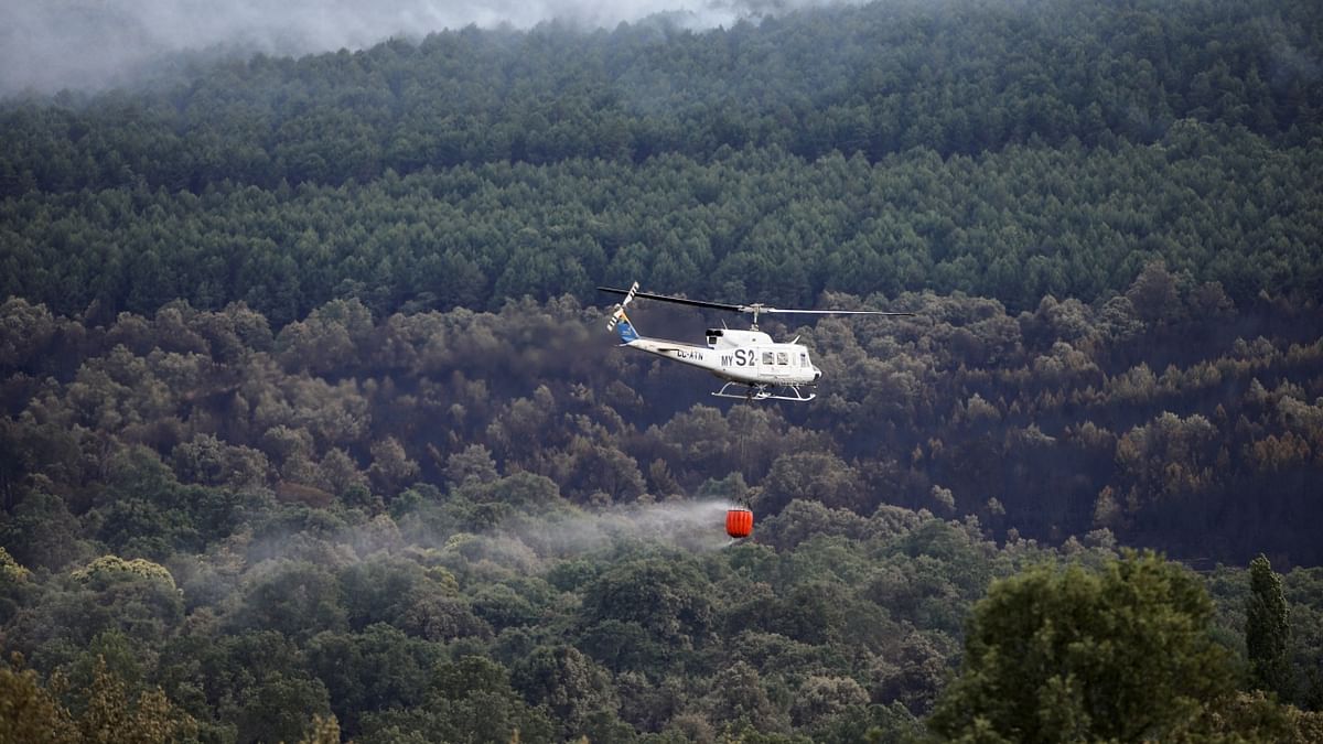 A helicopter drops river water onto a wildfire at the Sierra de la Culebra near Villanueva de Valrojo, Zamora, Spain. Credit: Reuters Photo