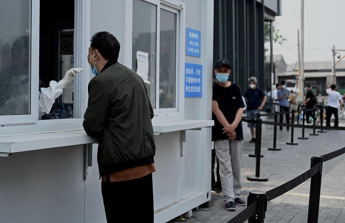A health worker takes a swab sample from a man to be tested for the Covid-19 coronavirus at a swab collection site in Beijing. Credit: AFP Photo