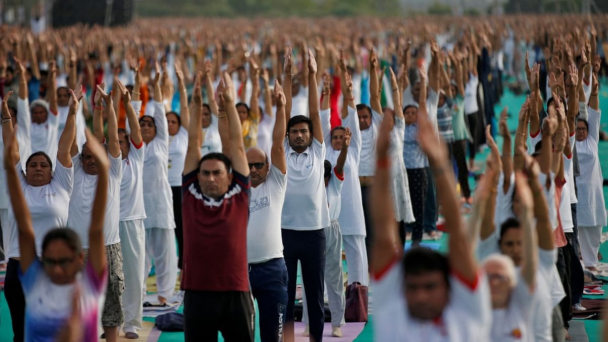People perform yoga at a riverfront on International Yoga Day in Ahmedabad. Credit: PTI Photo