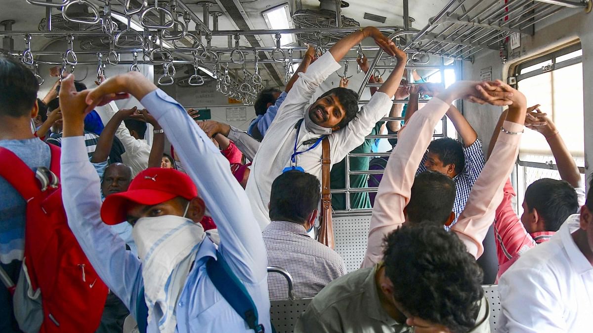 Passengers perform yoga while commuting on a local train as they celebrate the International Day of Yoga in Mumbai. Credit: AFP Photo