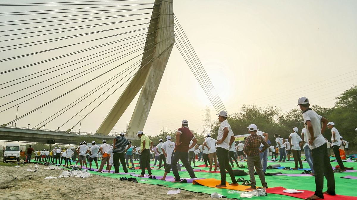 People perform yoga at the Signature Bridge on the 8th International Day of Yoga, in New Delhi. Credit: PTI Photo