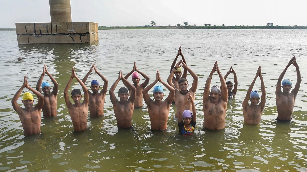 Youths perform yoga in the Ganga river, on the occasion of the 8th International Yoga Day, in Patna. Credit: PTI Photo