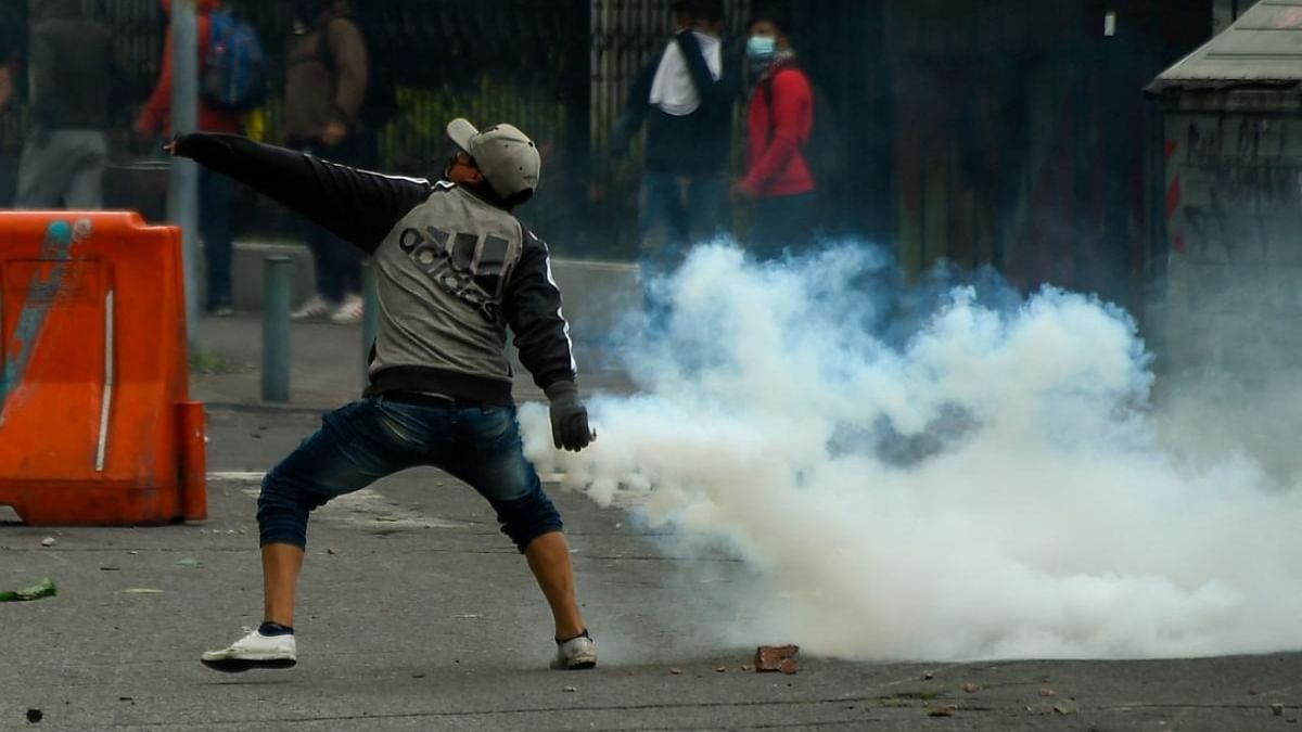 A demonstrator throws a tear gas canister at police officers during clashes in the El Arbolito park area in Quito, on June 22, 2022, on the tenth consecutive day of indigenous-led protests against the Ecuadorean government. Credit: AFP Photo