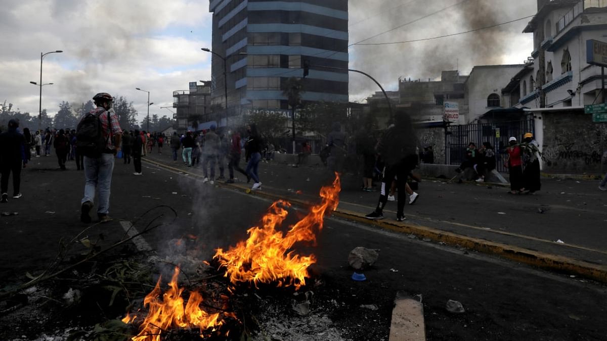 Protesters stand in front of a burning road blockade during a march to demand President Guillermo Lasso address price increases for fuel, food and other basics which have ignited 10 days of demonstrations across the country, in Quito, Ecuador. Credit: Reuters photo