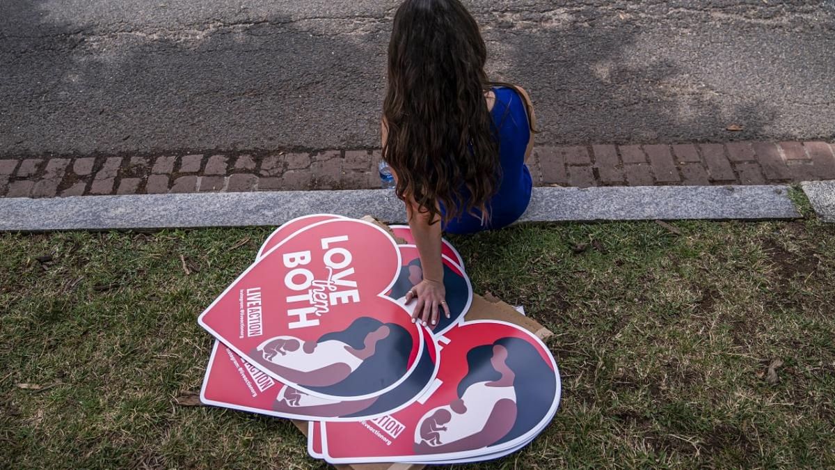A woman rests next to anti-abortion posters in front of the US Supreme Court after the Court announced a ruling in the Dobbs v Jackson Women's Health Organization case on June 24, 2022 in Washington. Credit: AFP Photo