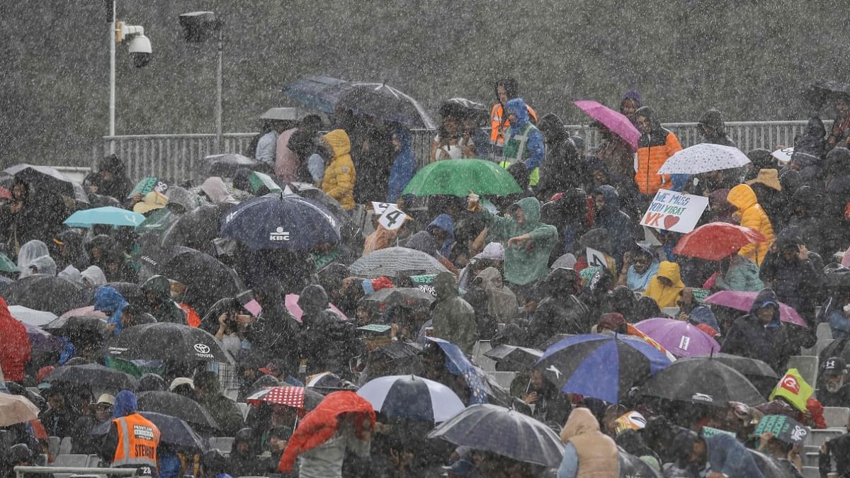 Spectators get wet as rain delays the start of play in the Twenty20 International cricket match between Ireland and India at Malahide cricket club, in Dublin. Credit: AFP Photo