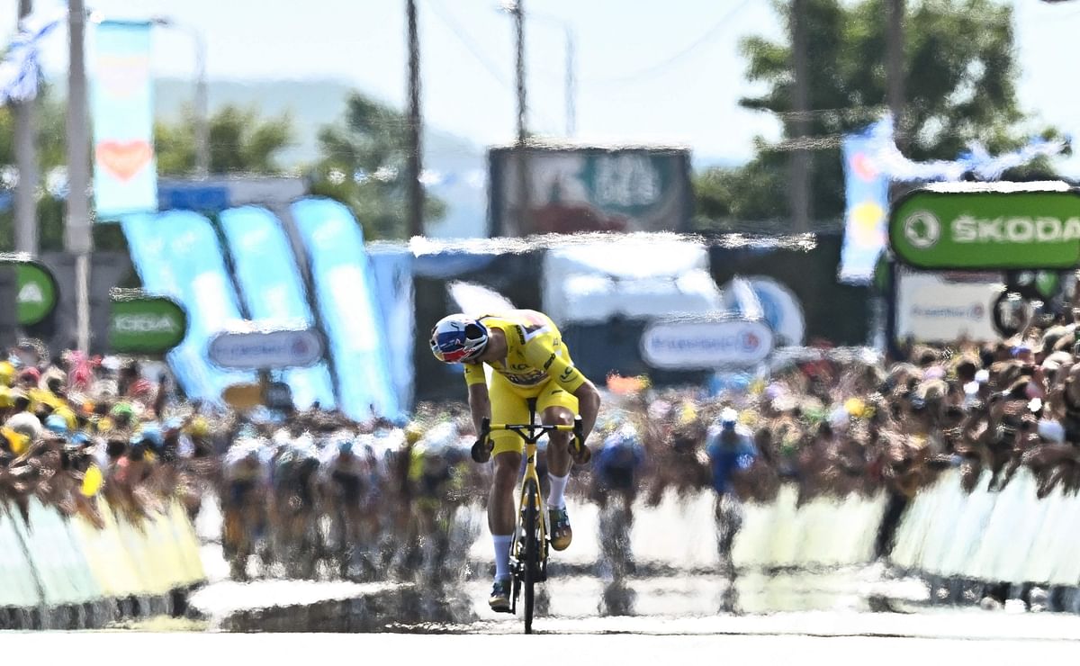 Jumbo-Visma team's Belgian rider Wout Van Aert looks back at the pursuing pack of riders as he cycles the final meters to the finish line to win the 4th stage of the 109th edition of the Tour de France cycling race. Credit: AFP Photo