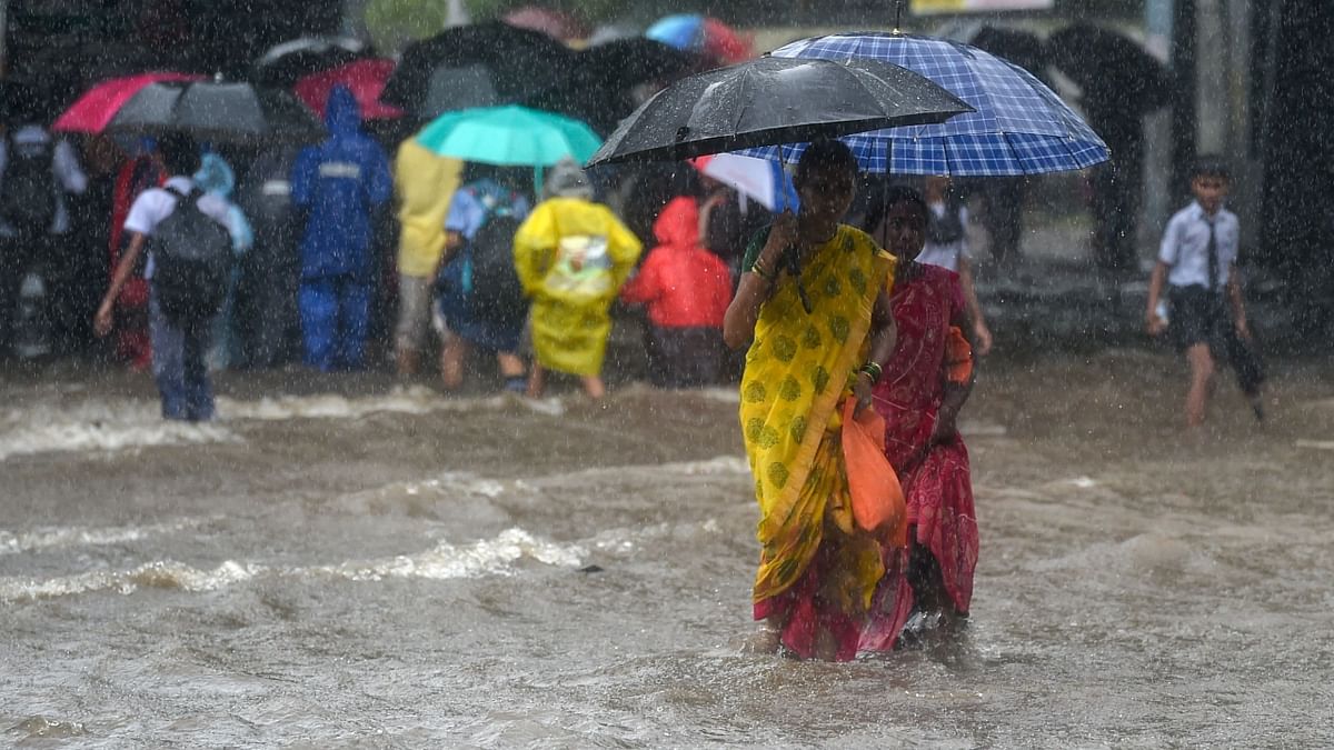 Pedestrians walk through a flooded street in Mumbai. Credit: AFP Photo