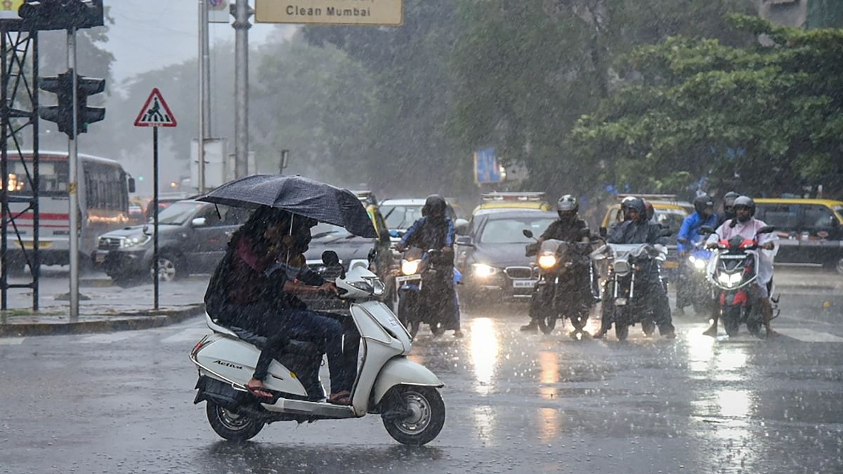 Commuters move on a road amid monsoon rains in Mumbai. Credit: PTI Photo