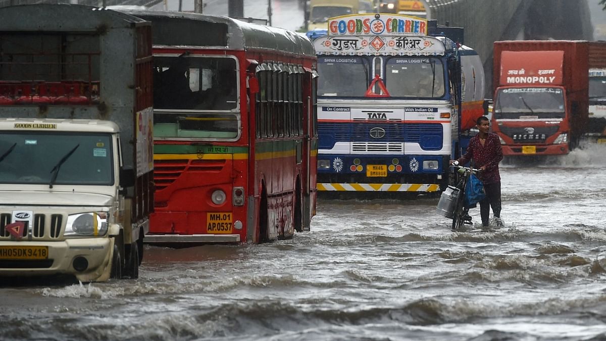 Vehicles drive through a flooded street during the rains in Mumbai. Credit: AFP Photo