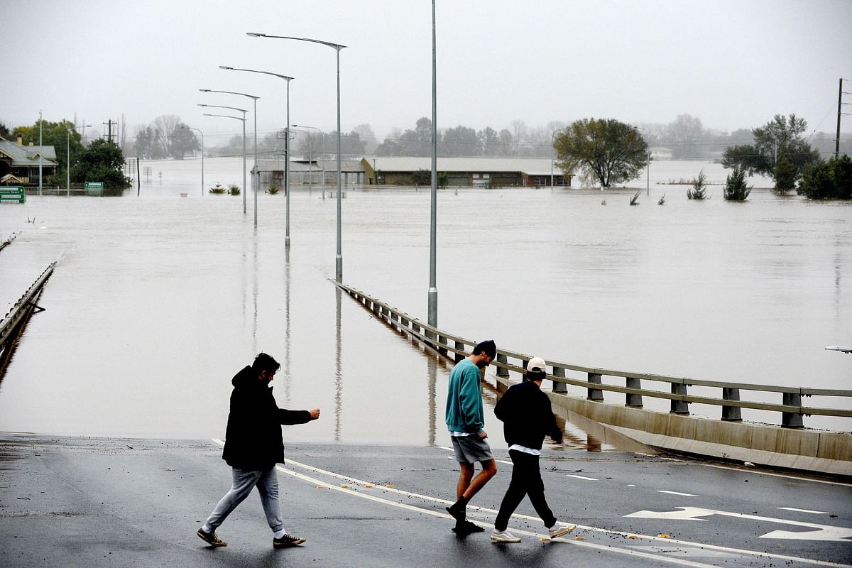 People walk over an old Windsor Bridge along the overflowing Hawkesbury River in the northwestern Sydney suburb of Windsor. Credit: AFP Photo