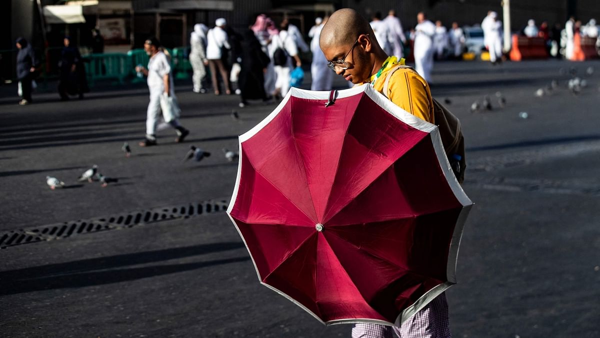 Many pilgrims held umbrellas to block the hot sun as the temperature climbed to 42 degrees Celsius (108 Fahrenheit). Credit: AFP Photo