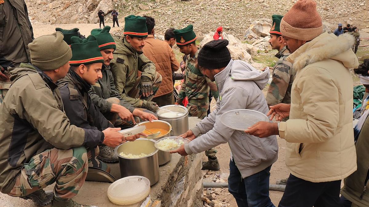 Army personnel offer food to pilgrims a day after flash floods triggered by a cloudburst, near the Amarnath cave shrine in J&K. Credit: Indian Army