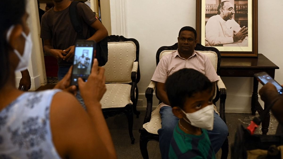 A demonstrator is seen posing for pictures inside Sri Lanka's presidential palace, in Colombo.AFP Photo