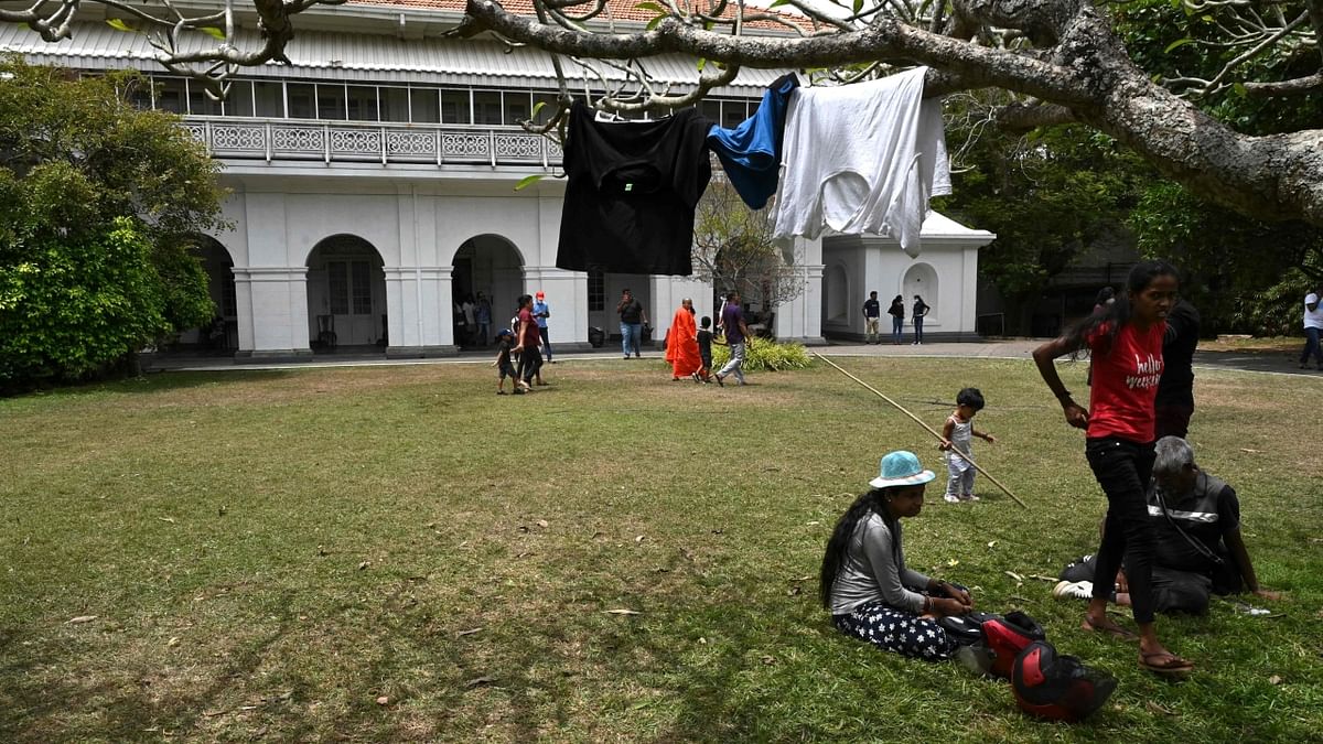 People dry their clothes inside the premises of the official residence of Sri Lanka's Prime Minister, in Colombo. Credit: AFP Photo