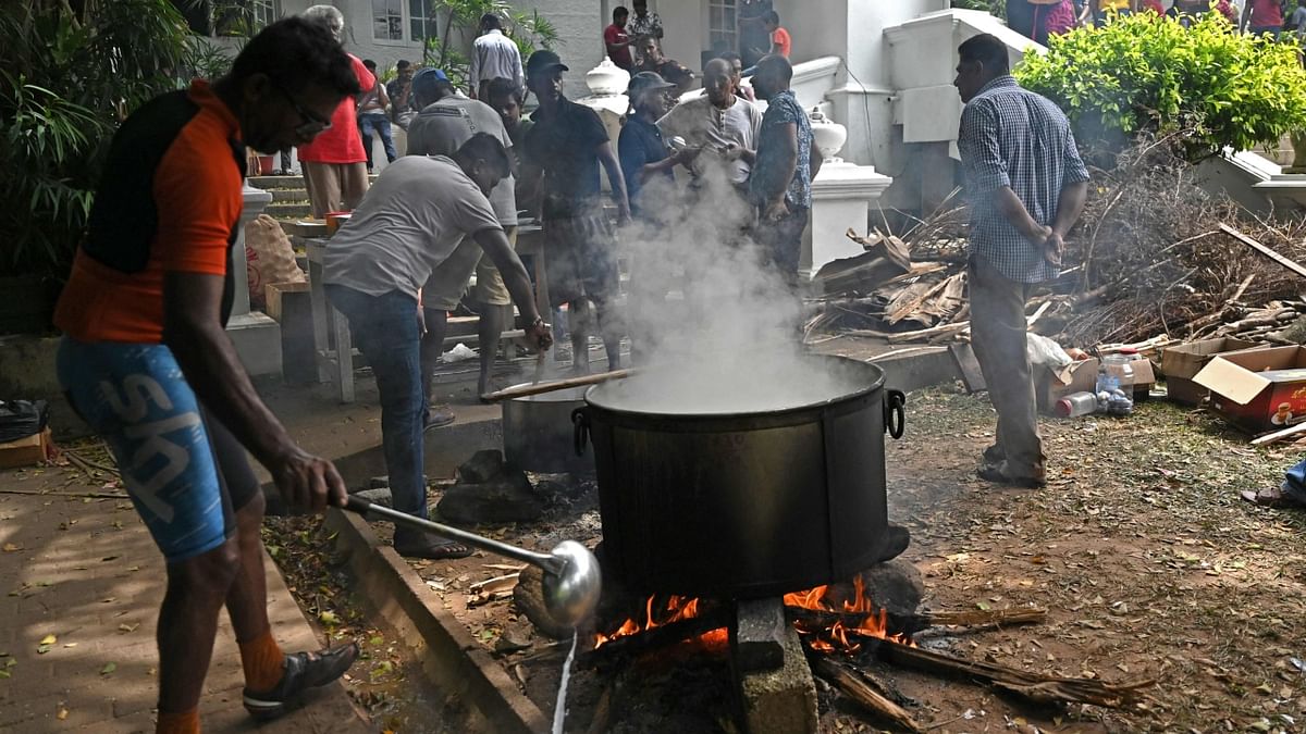 People cook food inside the premises of the official residence of Sri Lanka's Prime Minister, in Colombo. Credit: AFP Photo