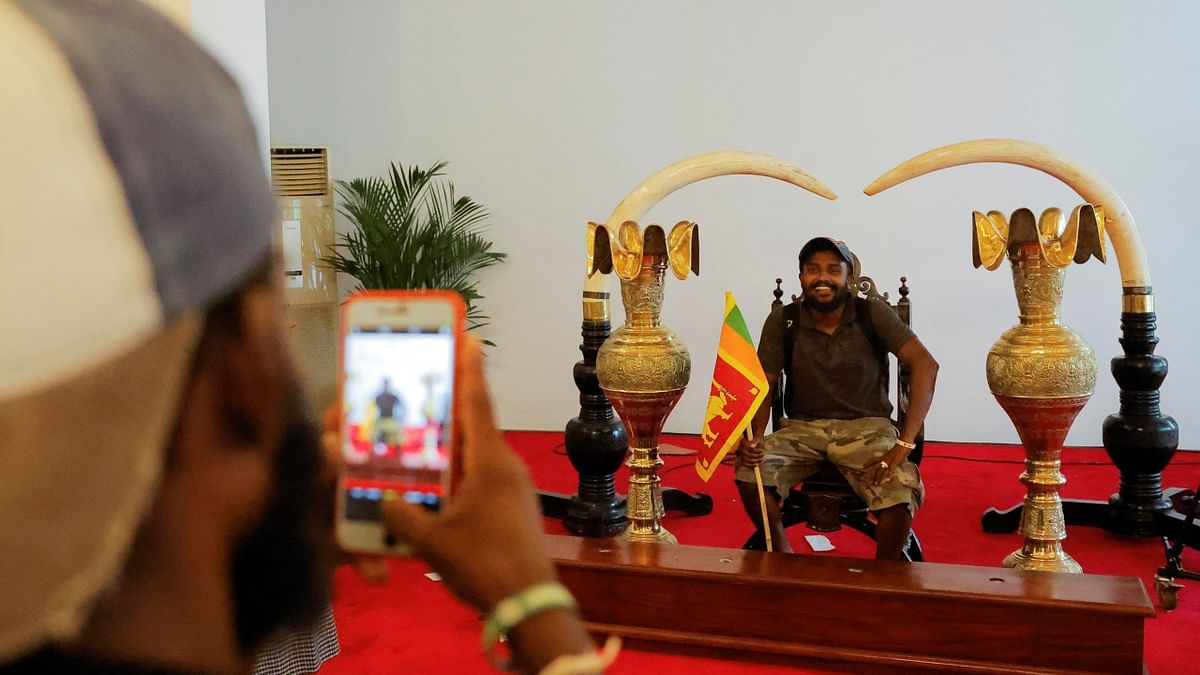 A demonstrator poses for photographs where President Gotabaya Rajapaksa used to hold main events at the President's house on the following day after demonstrators entered the building, after President Gotabaya Rajapaksa fled, amid the country's economic crisis, in Colombo, Sri Lanka. Credit: Reuters Photo