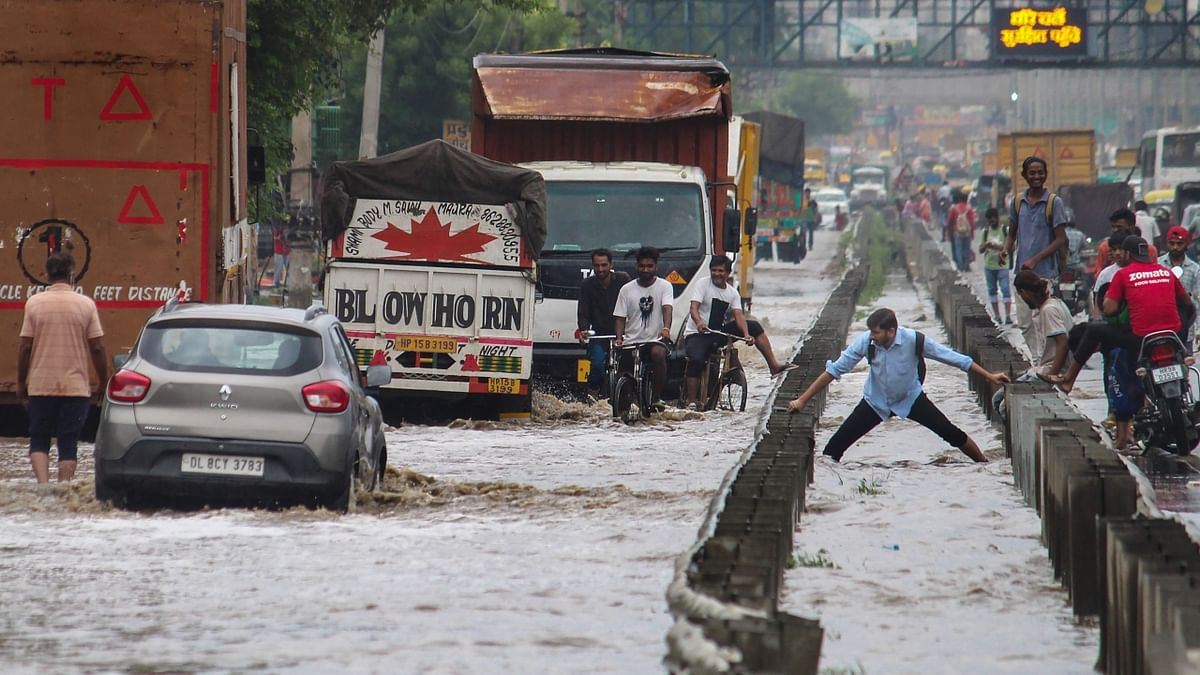 Vehicles wade through a waterlogged service road of the Delhi- Gurugram Expressway after heavy monsoon rains, in Gurugram. Credit: PTI Photo
