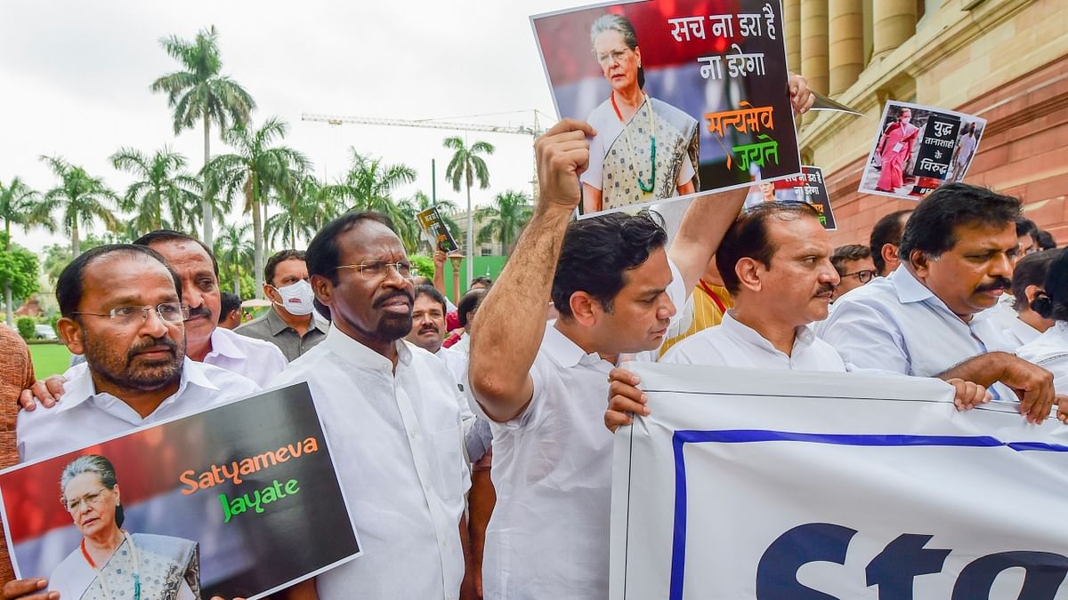Congress MPs shout slogans as they stage a protest march at Parliament House complex in solidarity with the party chief Sonia Gandhi. Credit: PTI Photo