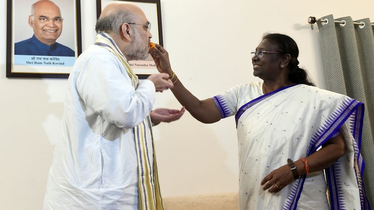 President-elect Droupadi Murmu feeds a sweet to Union Home Minister Amit Shah, in New Delhi. Credit: PTI Photo