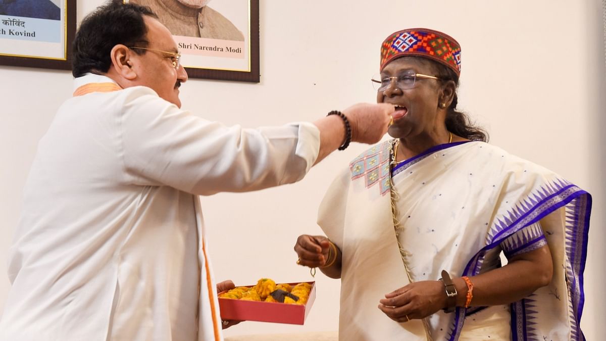 BJP National President JP Nadda offers sweets to Droupadi Murmu as he congratulates her on winning the presidential elections. Credit: PTI Photo