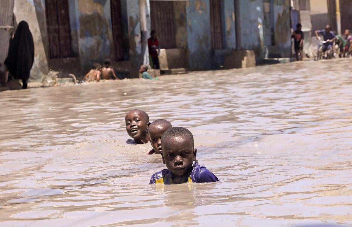 Somali boys wade in flooded waters after a heavy rainfall, in the Wadajir district of Mogadishu. Credit: Reuters Photo