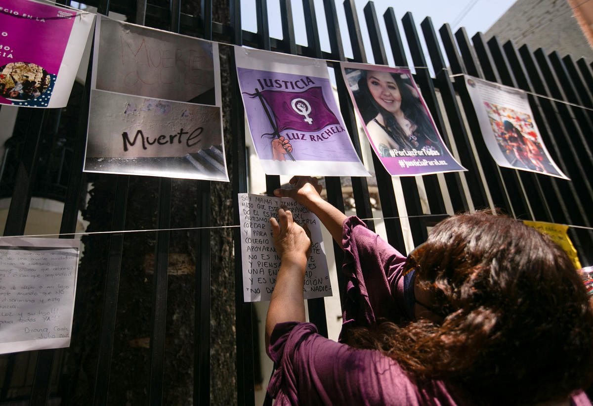 A woman hangs up a message for Luz Raquel Padilla, a femicide victim who was doused with alcohol and burnt by unknown assailants, in Mexico City. Credit: Reuters Photo