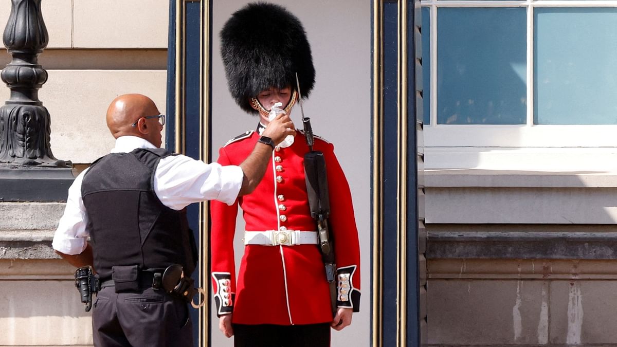 A police having to water Queen's Guard outside Buckingham Palace because of the hot weather. Credit: Reuters Photo