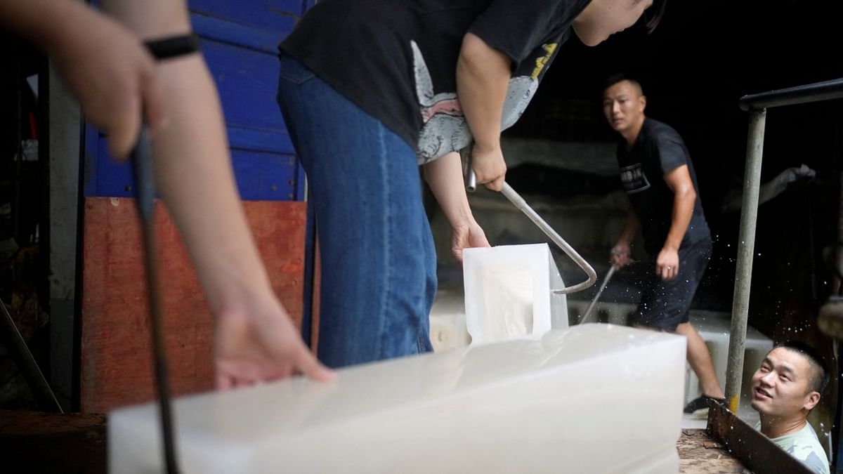 Employees move ice blocks onto a truck at Shanghai Yuhu ice-making factory, amid a heatwave warning in Shanghai, China. Credit: Reuters Photo