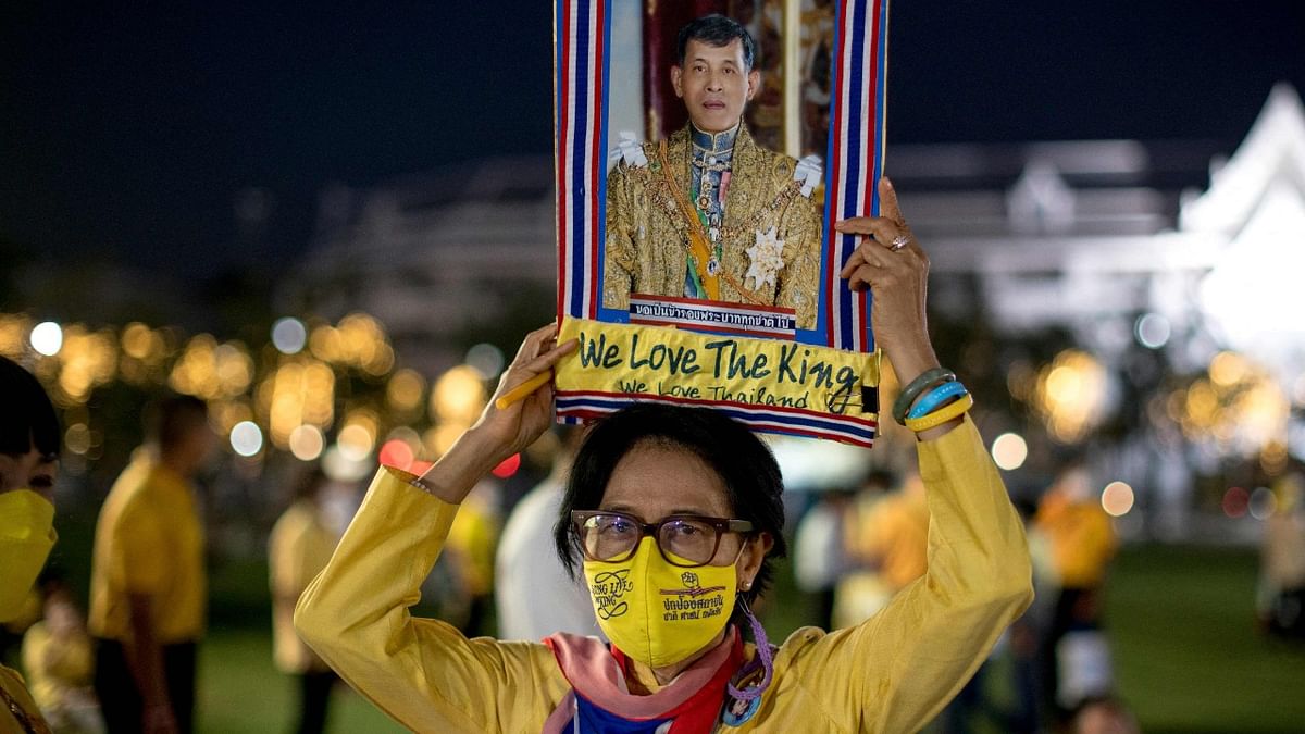 A royal supporter holds up a portrait of Thailand's King Maha Vajiralongkorn during celebrations to mark the King's 70th birthday outside the Grand Palace in Bangkok. Credit: AFP Photo