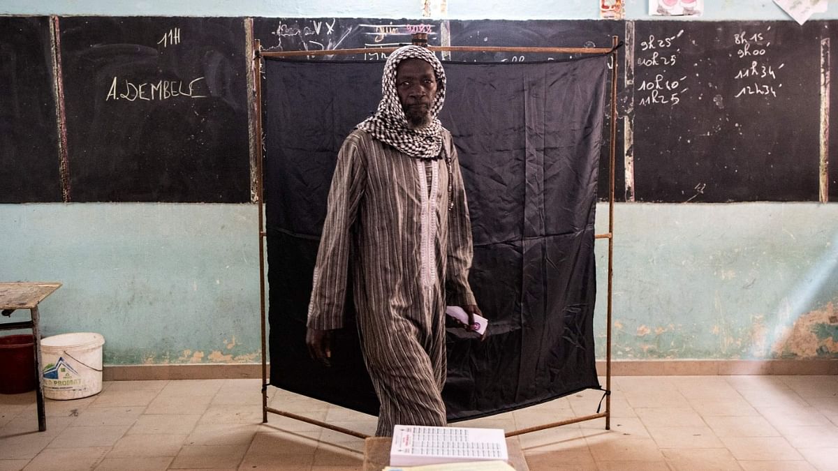 A man leaves a voting booth in the popular neighbourhood of Ngor in Dakar on July 31, 2022. Senegalese voters head to the polls Sunday for parliamentary elections the opposition hopes will force a coalition with President Macky Sall and curb any ambitions he may hold for a third term. Credit: AFP Photo
